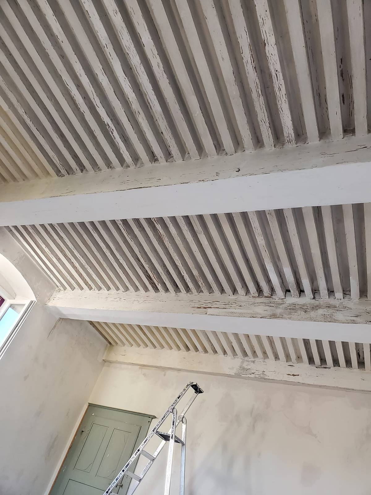 Plafond à poutres et solives dégradé avant travaux.