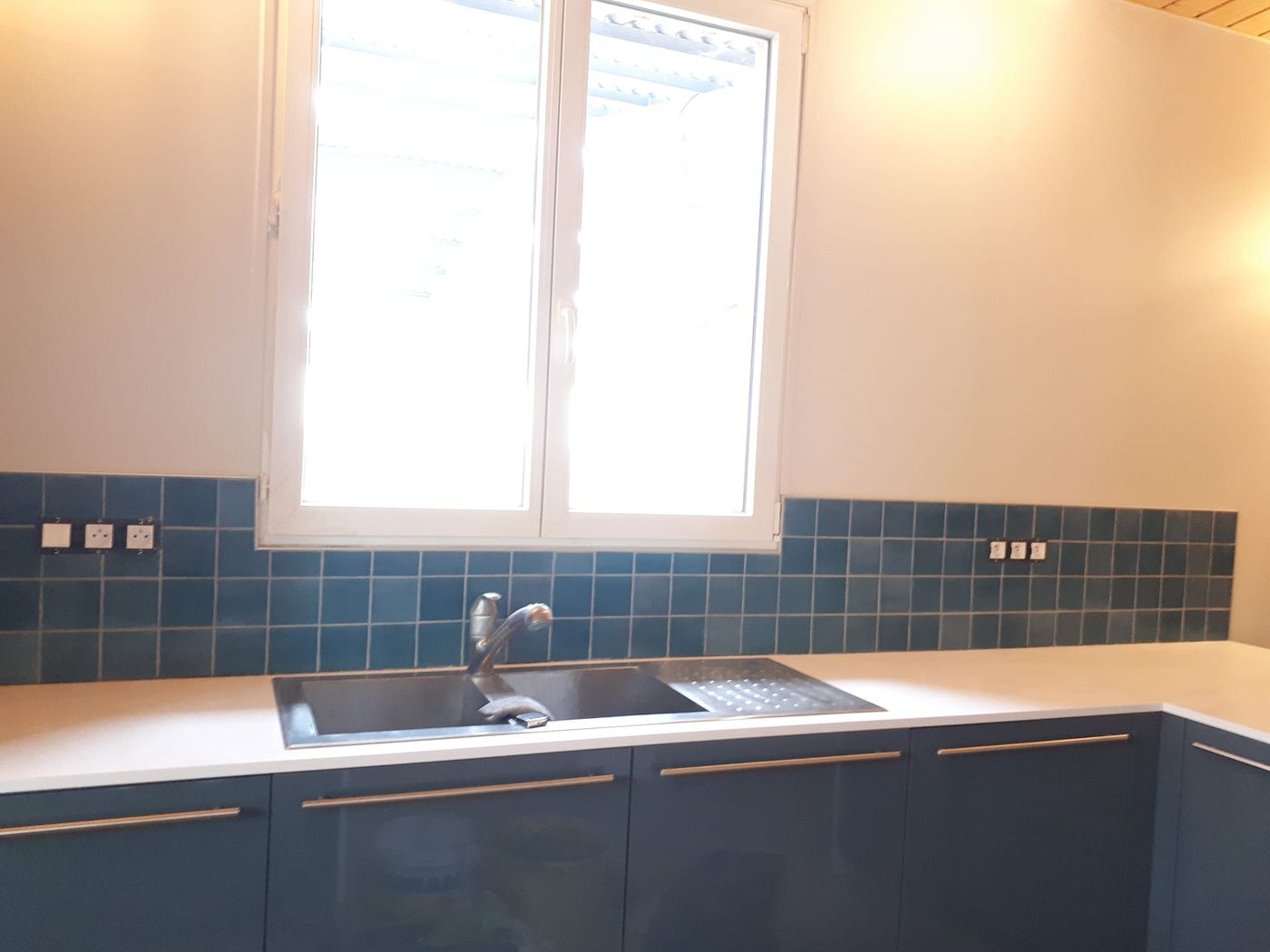 Crédence en carreaux de Salerne bleu-vert au-dessus d'un plan de travail clair.