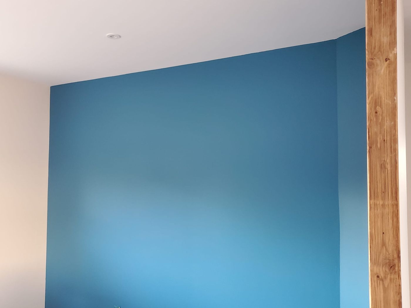 Mur sous rampant fraîchement peint dans un bleu profond.
