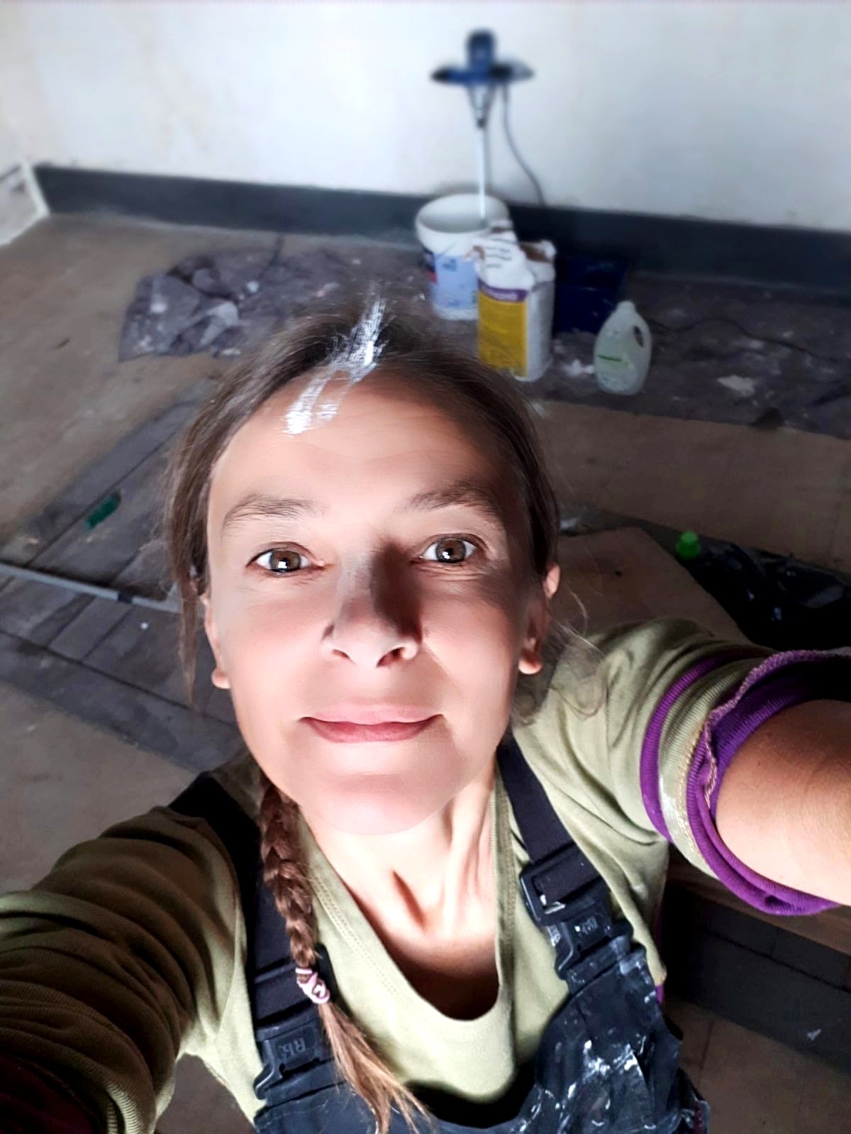 Clémence Drouhard en salopette de travail sur un chantier de rénovation.
